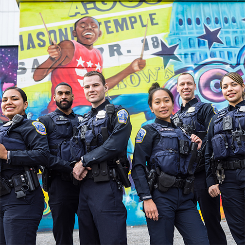 Officers in front of a mural